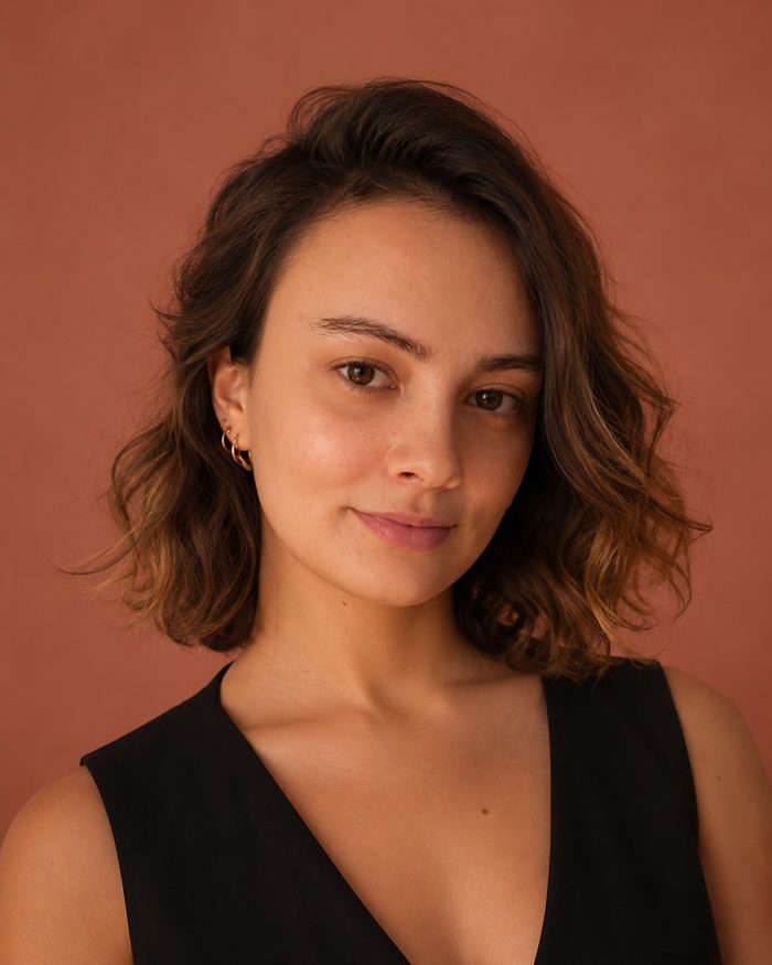 Anna Guerrini, smiling, against a warm clay backdrop.