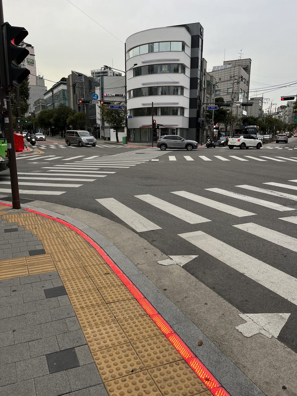 LED strip on the pavement at a Seoul crosswalk, glowing to show the pedestrian signal